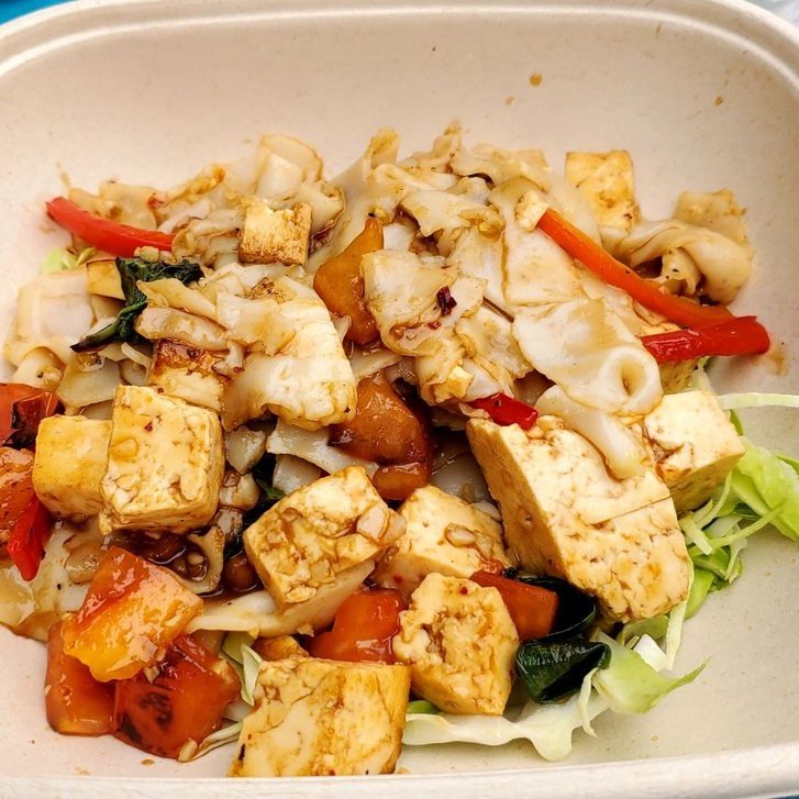 Drunken noodle with wide rice noodles, tofu, tomato and chili